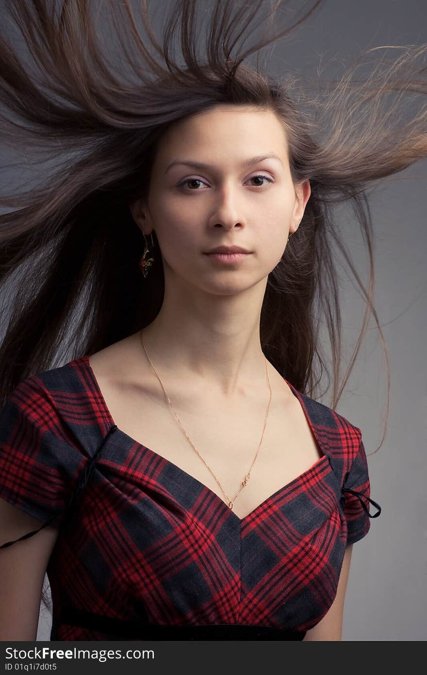 Woman with fluttering hair. On dark background.