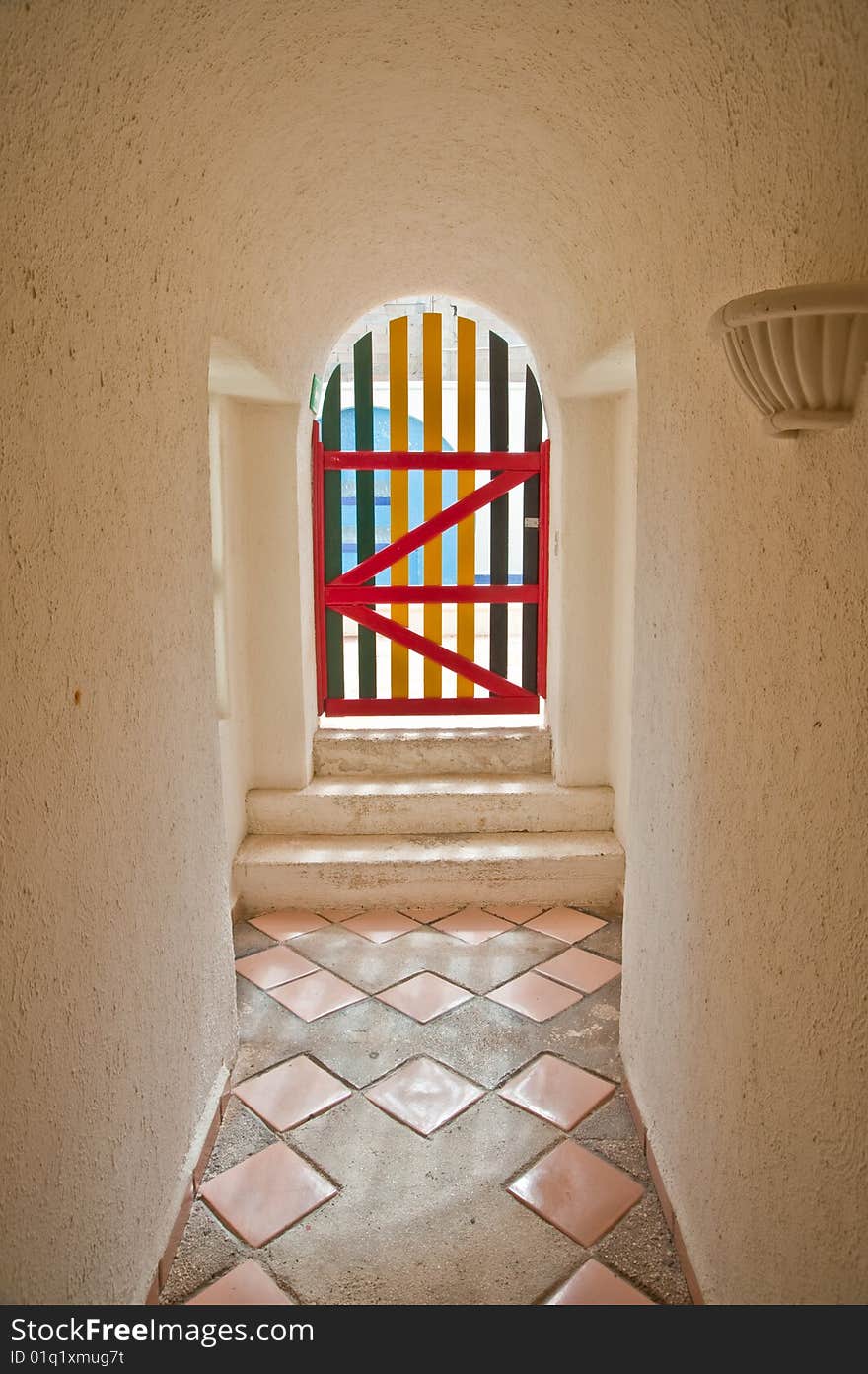 A colorful wooden door by the end of a hall way. A colorful wooden door by the end of a hall way