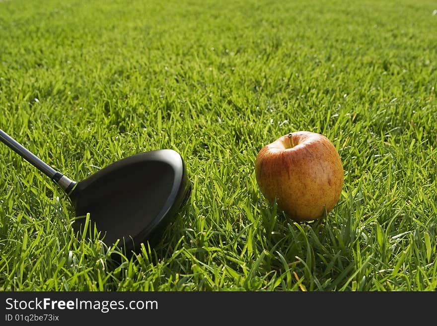 Golfer preparing to drive an apple downrange. Golfer preparing to drive an apple downrange.