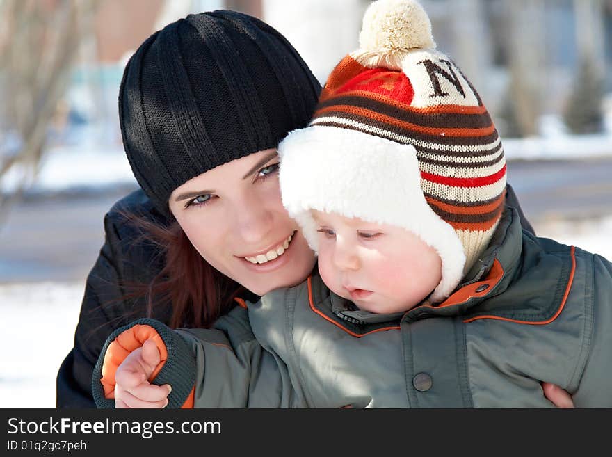 Portrait of young mum with the son in the winter on walk. Portrait of young mum with the son in the winter on walk