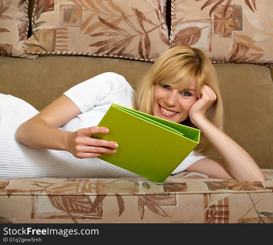 The beautiful girl sits at home with a folder for documents. The beautiful girl sits at home with a folder for documents