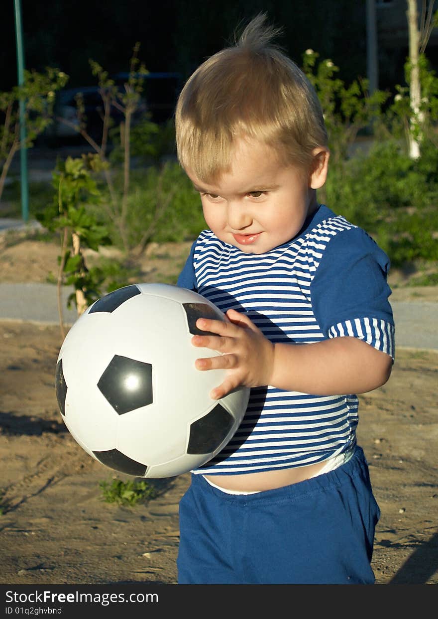 The boy with a football on walk. The boy with a football on walk