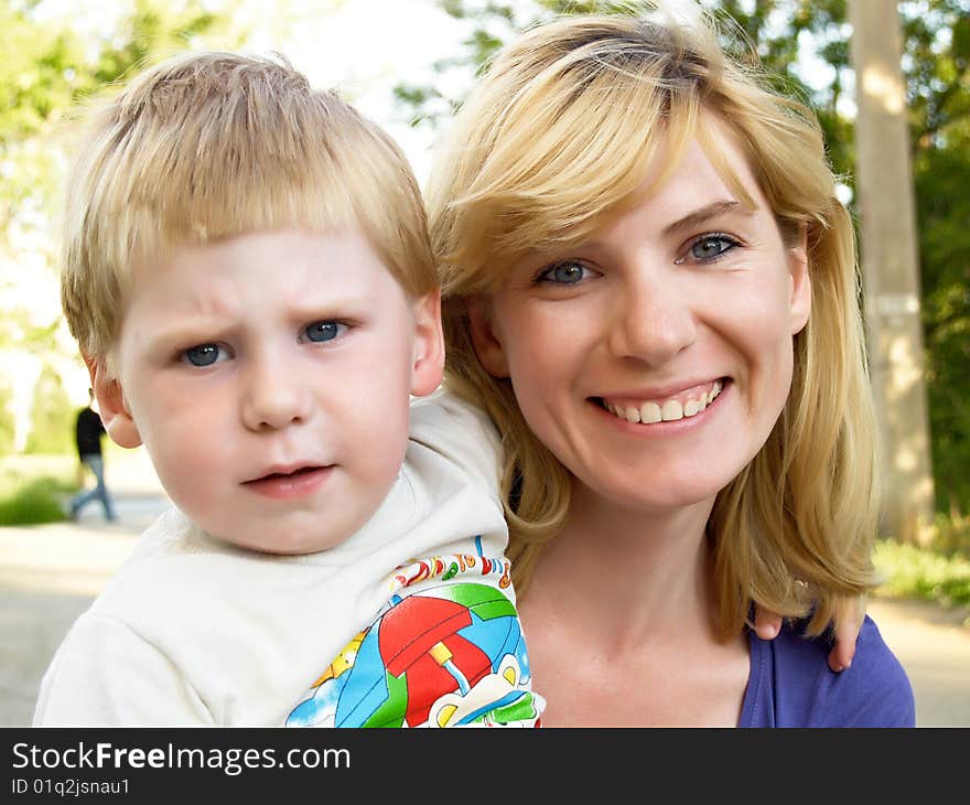 Woman and young boy outdoors embracing and smiling. Woman and young boy outdoors embracing and smiling