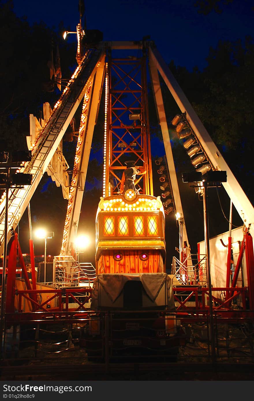 Illuminated Construction of carousel in evening park