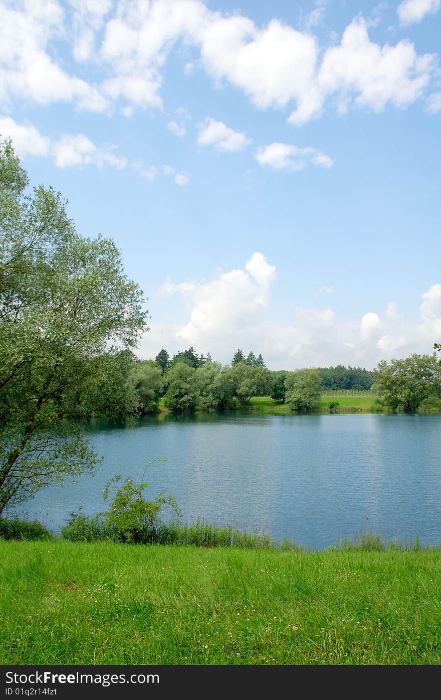 Beautiful summer landscape with a lake, meadows and sky