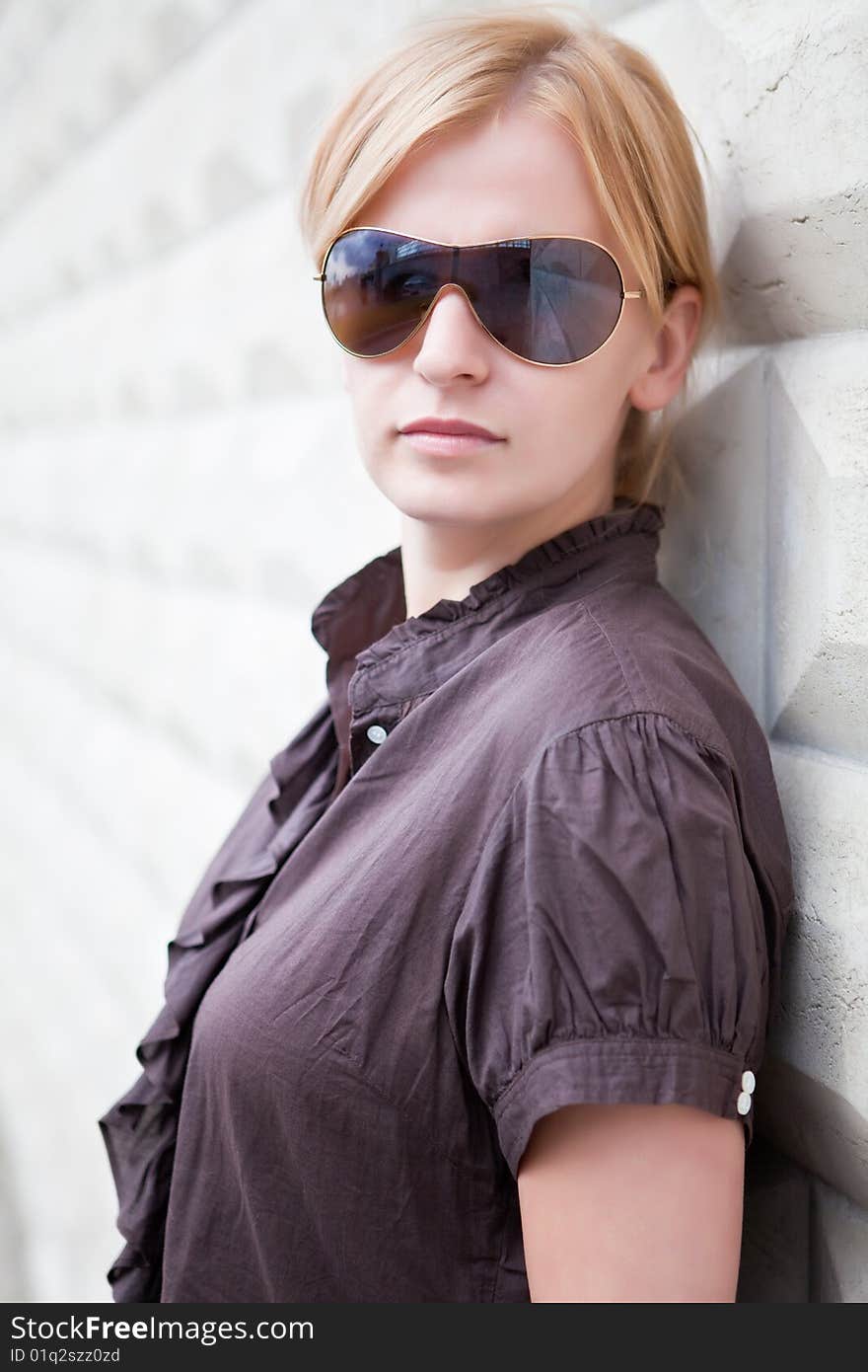 Beautiful girl near to a white concrete fence. Beautiful girl near to a white concrete fence