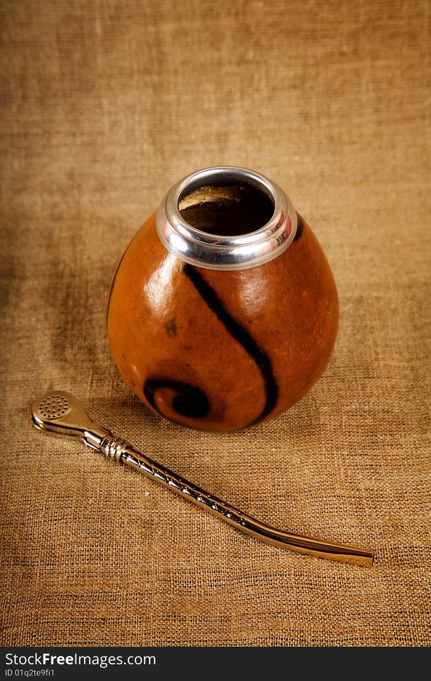 Argentinean Calabash with Bombilla over canvas background, selective focus