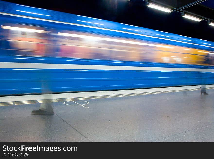 Moving blue train people walking