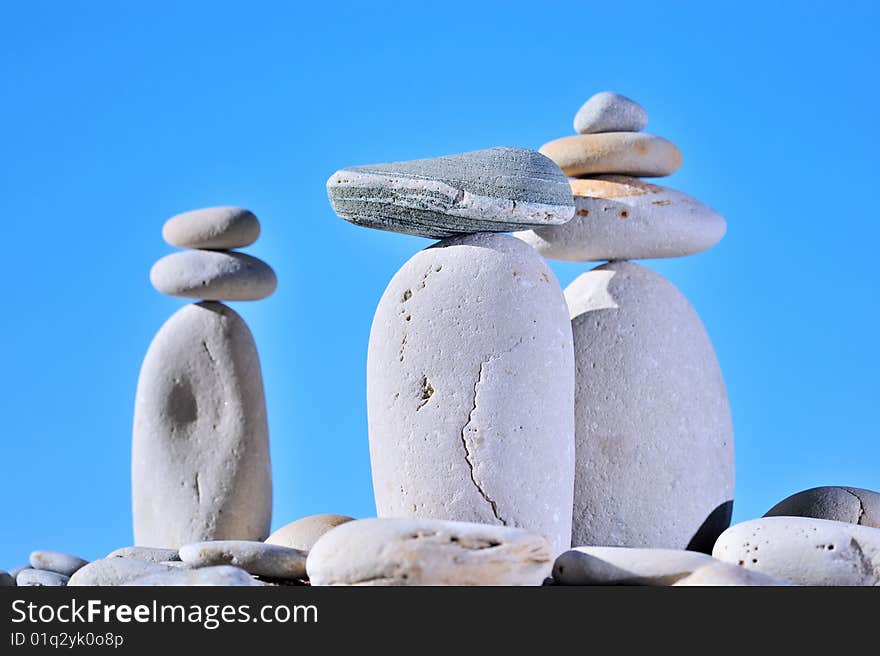 Balance of small stones on three long cobblestones. Balance of small stones on three long cobblestones