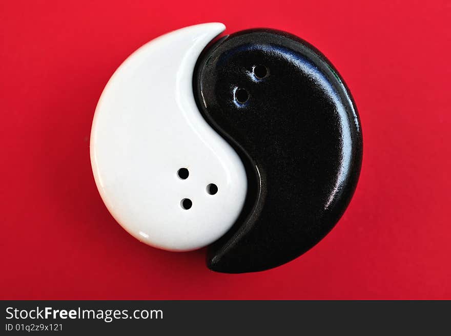 Graphic symbol of Yin and Yang, on a red background. Graphic symbol of Yin and Yang, on a red background