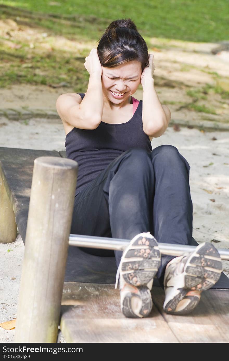 Fit asian female doing exercise - crunches