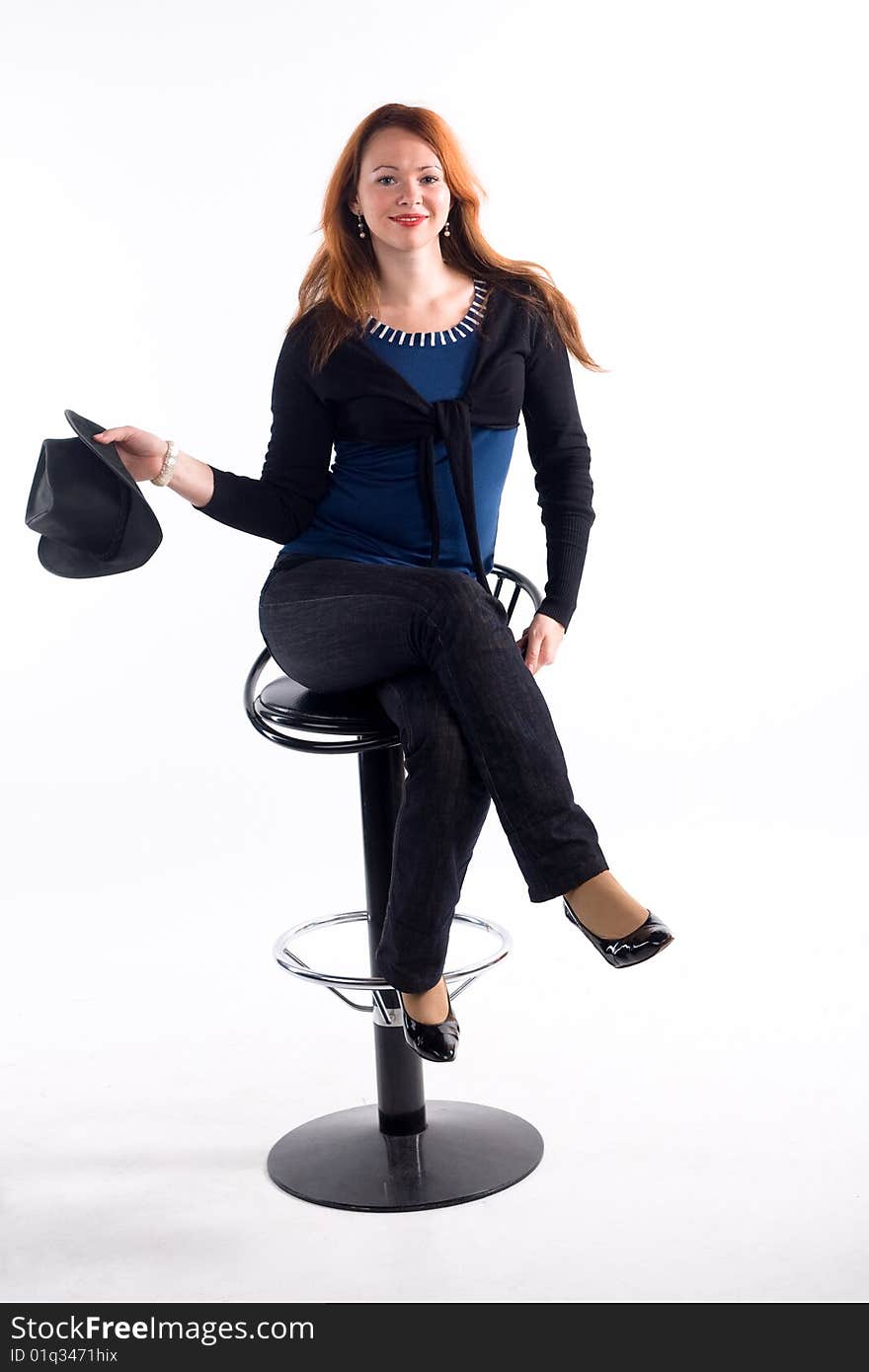 Young girl with  black hat sitting on chair on white background. Young girl with  black hat sitting on chair on white background