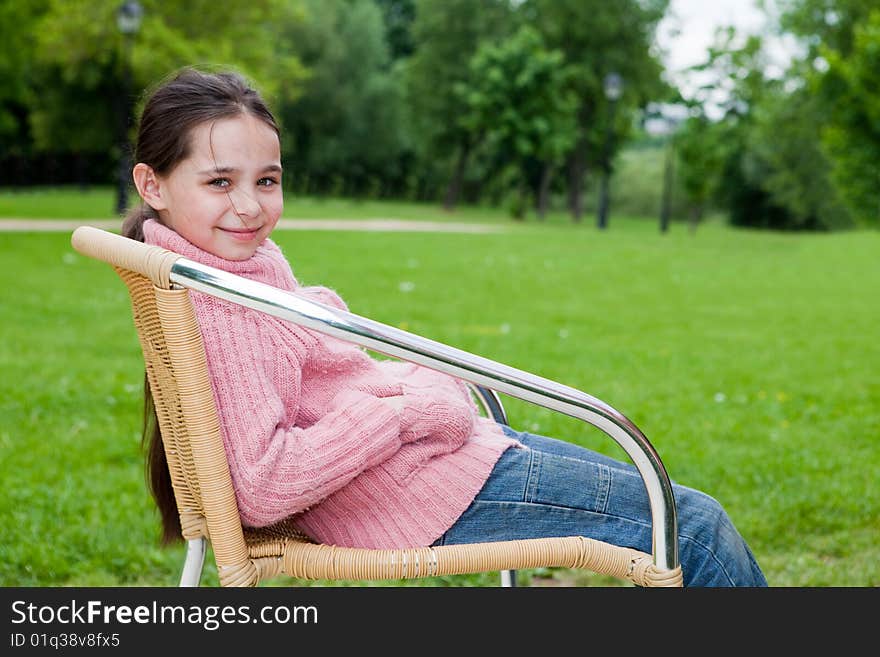 Girl sits on a chair against the nature. Girl sits on a chair against the nature