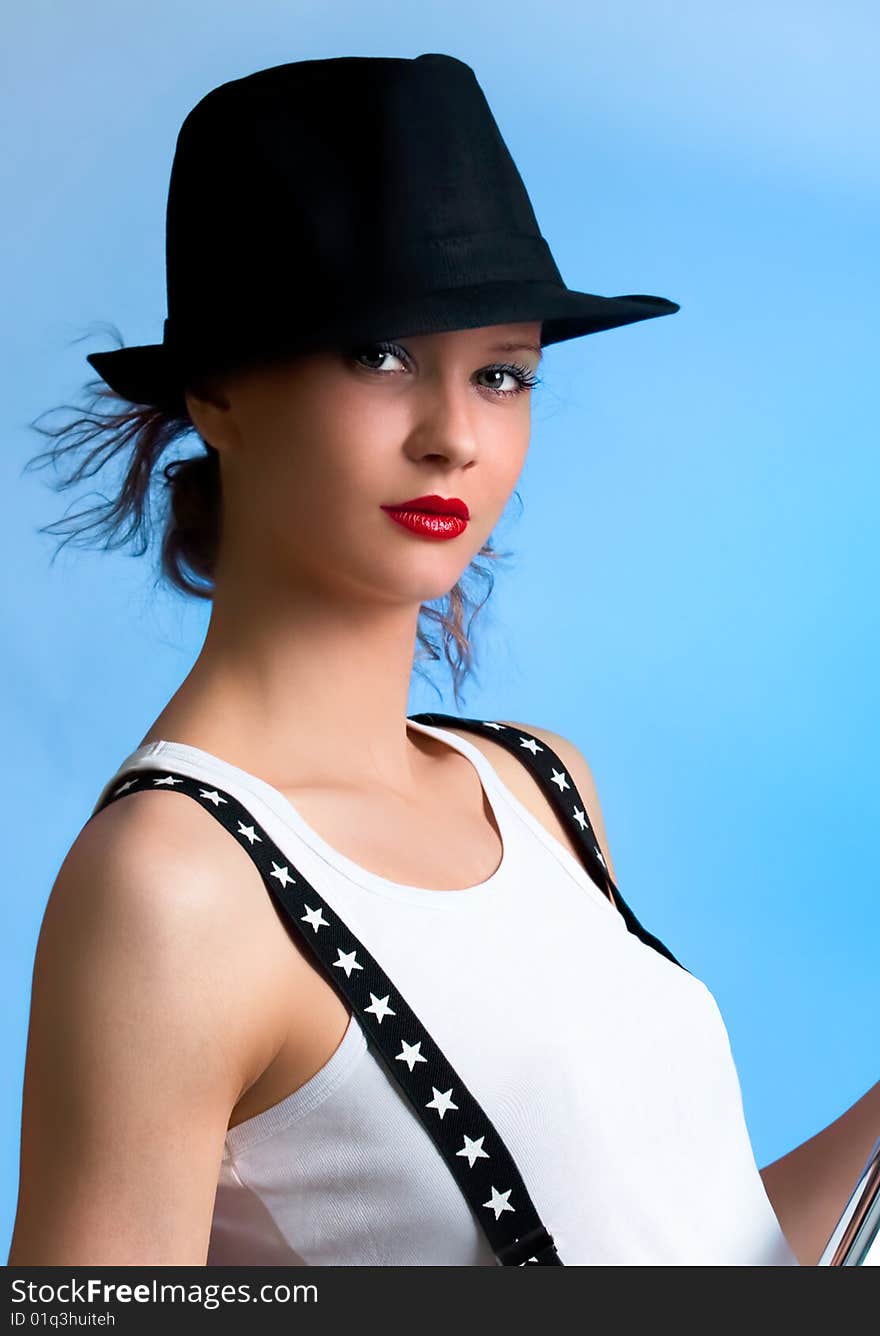 Beautiful woman with back hat posing in studio