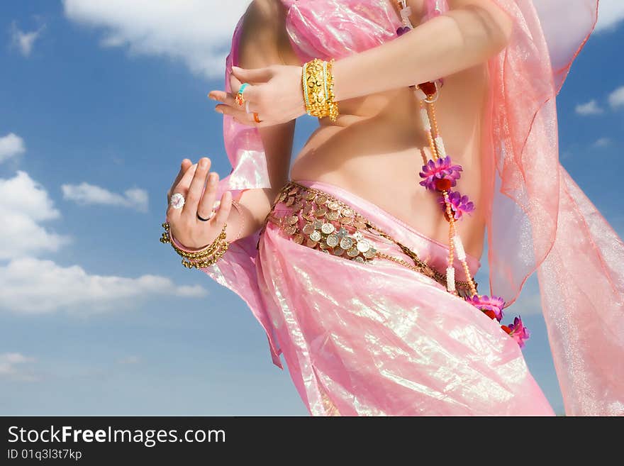 A woman in pink dress dancing close-up and a sky with clouds. A woman in pink dress dancing close-up and a sky with clouds