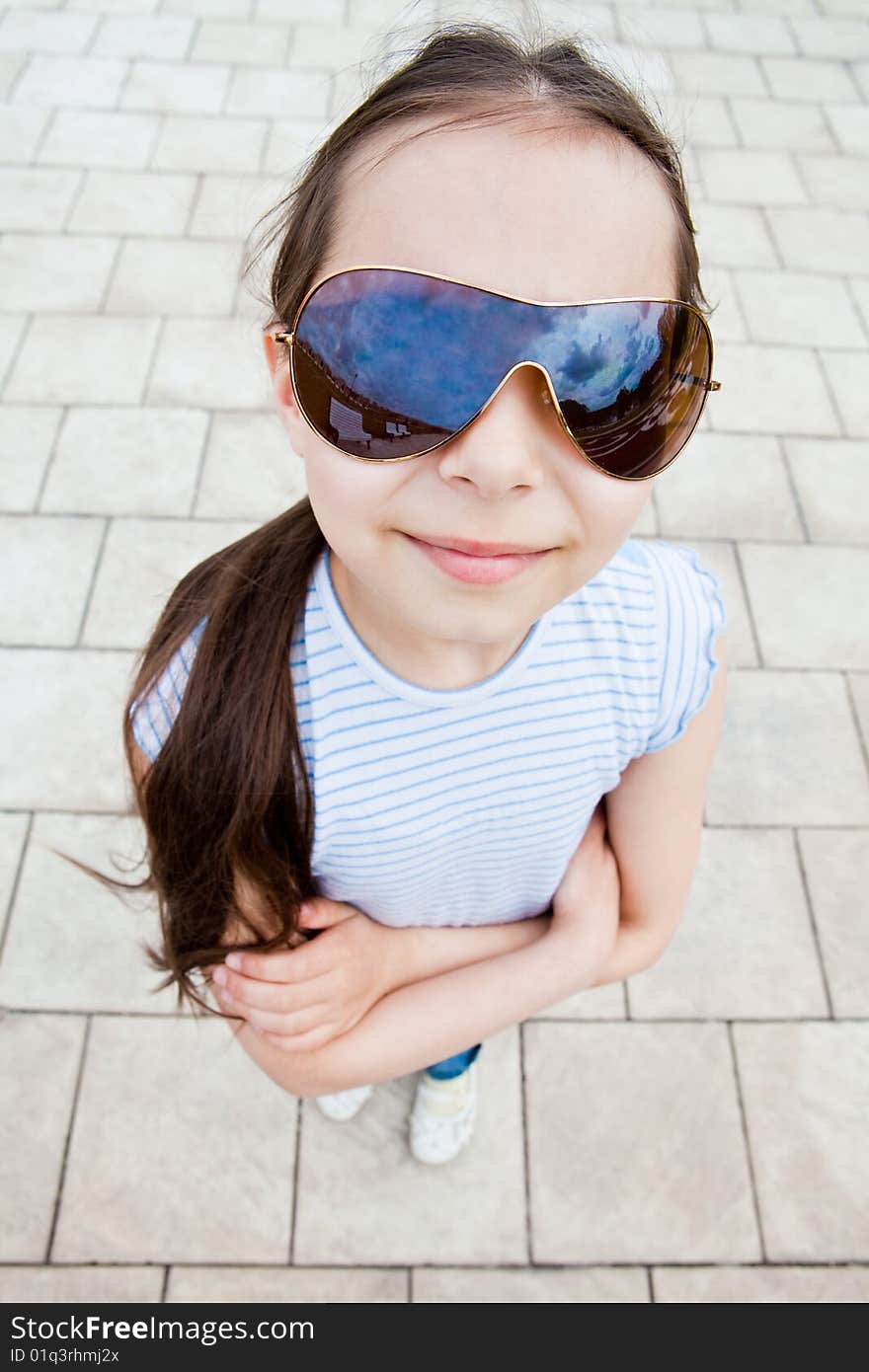 Girl in sun glasses looks at the sky