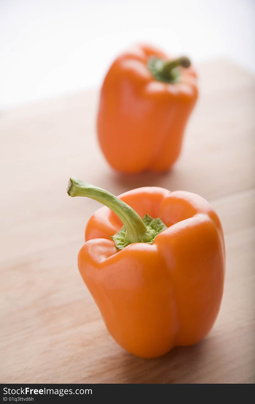 Orange peppers  together on chopping wood