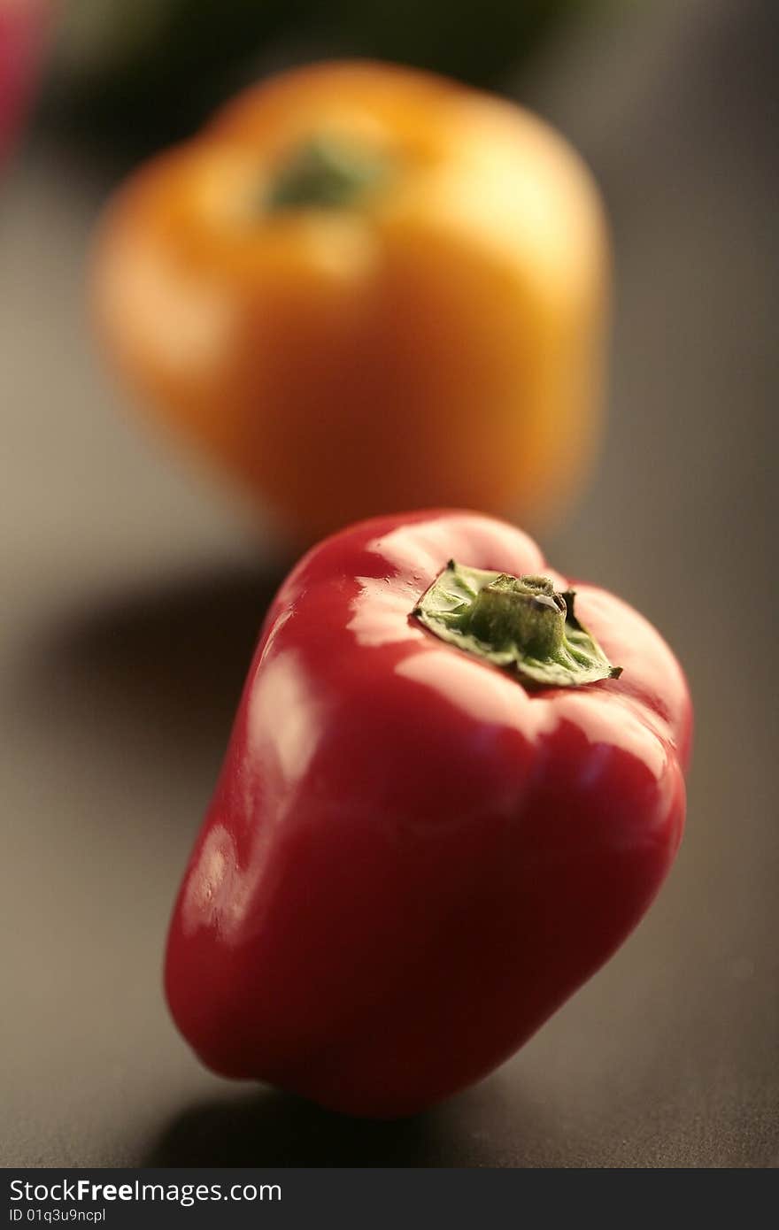 Closeup colored peppers on black plate