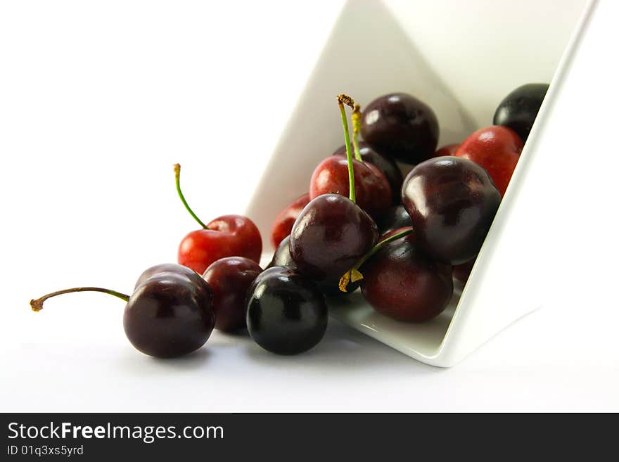 Spilt bowl of cherries with white background with clipping path