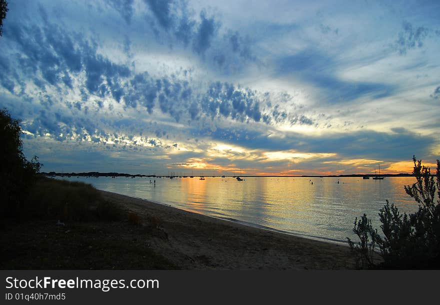 Interesting clouds at sunset over the calm ocean waters. Interesting clouds at sunset over the calm ocean waters