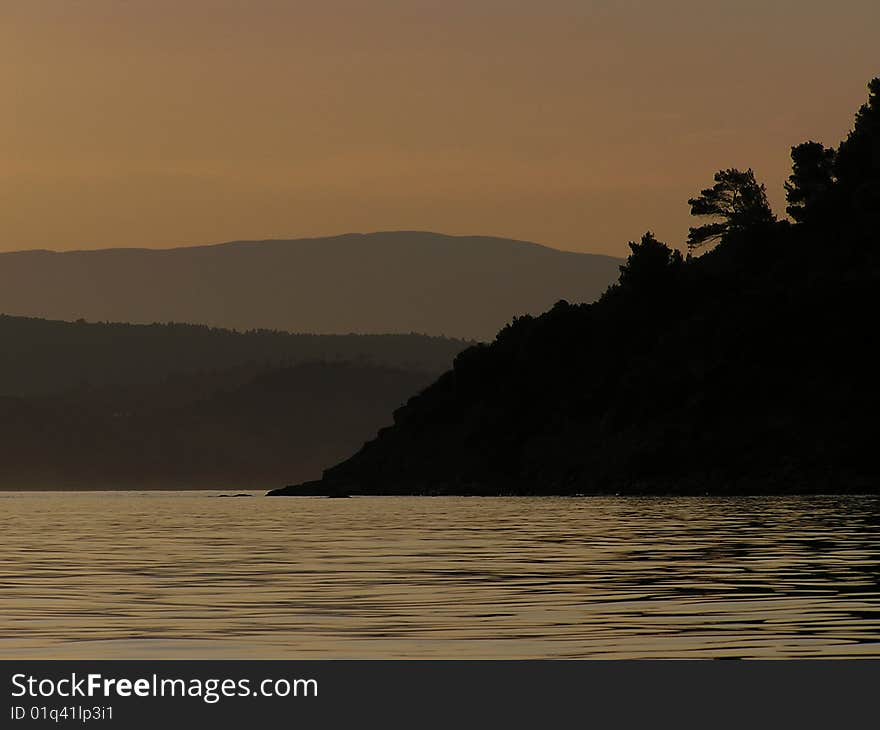 Landscape at sunset with reflection in sea water. Landscape at sunset with reflection in sea water.