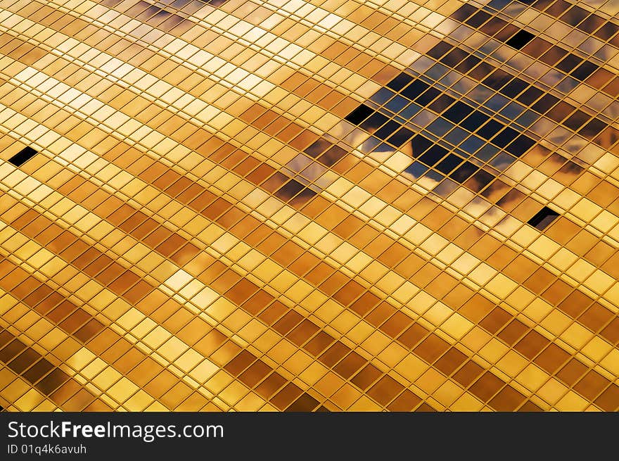 Office building gold windows with clouds mirror