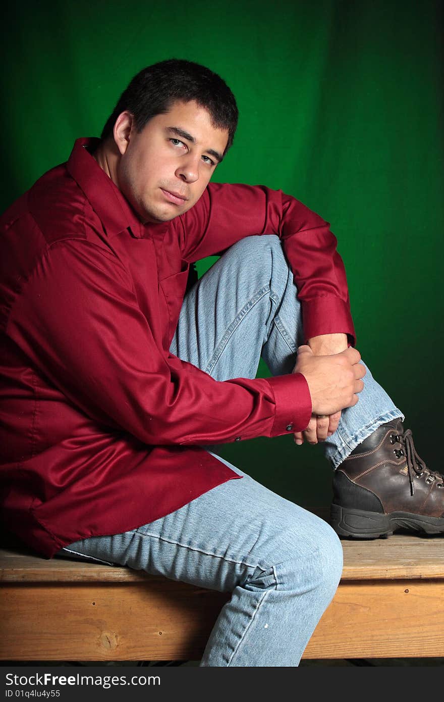 Portrait of a man sitting ona bench with a green background. Portrait of a man sitting ona bench with a green background