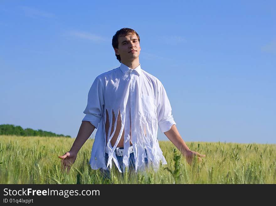 The man in the field relaxes. The man in the field relaxes