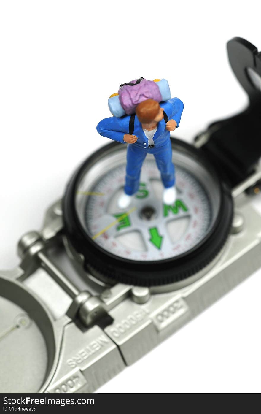 A figurine standing on a compass. A figurine standing on a compass