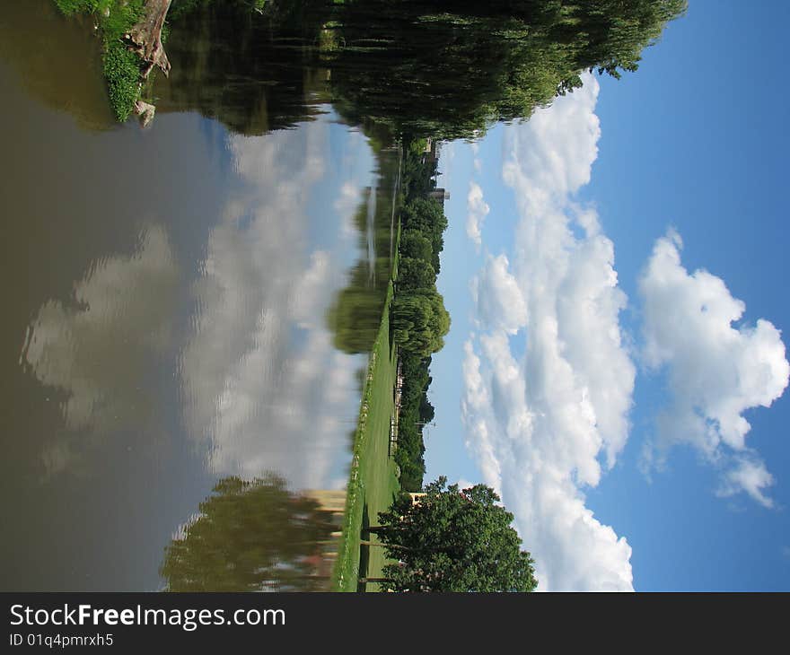 A bright blue sky, white fluffy clouds, a lazy river, green grass & weeping willow trees. A bright blue sky, white fluffy clouds, a lazy river, green grass & weeping willow trees.