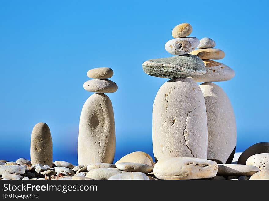 White long pebbles on a background of blue sky. White long pebbles on a background of blue sky