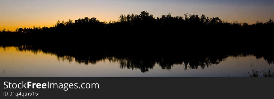 North woods silhouette in the still water of Island Lake in Northern Minnesota. North woods silhouette in the still water of Island Lake in Northern Minnesota