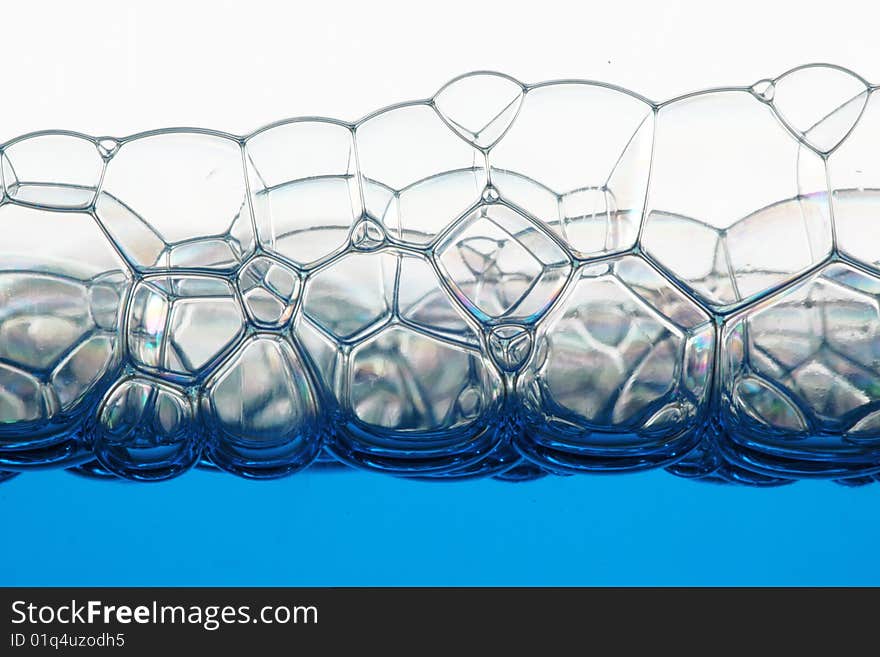 Macro of soap blue bubbles against white background