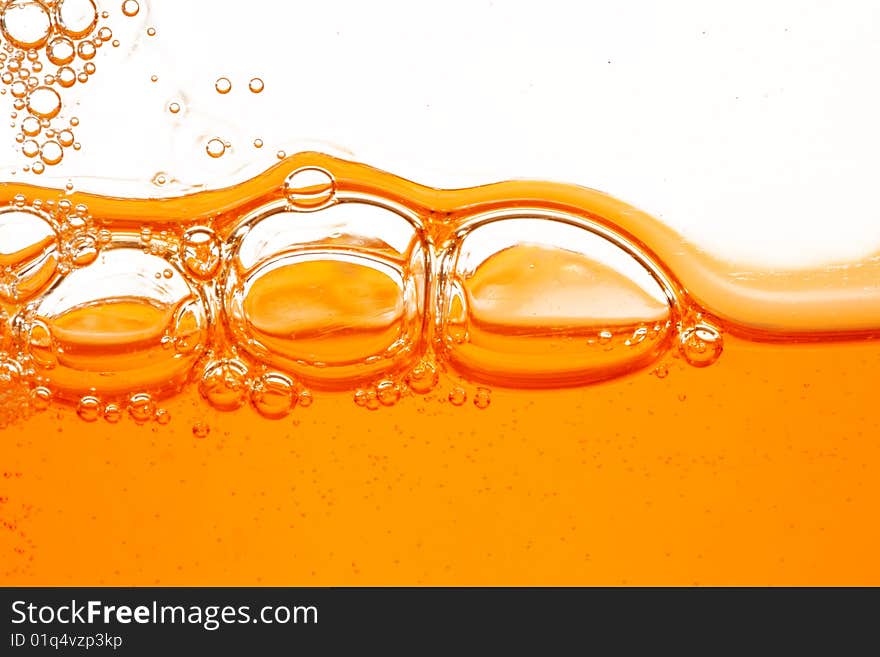 Macro of soap orange bubbles against white background