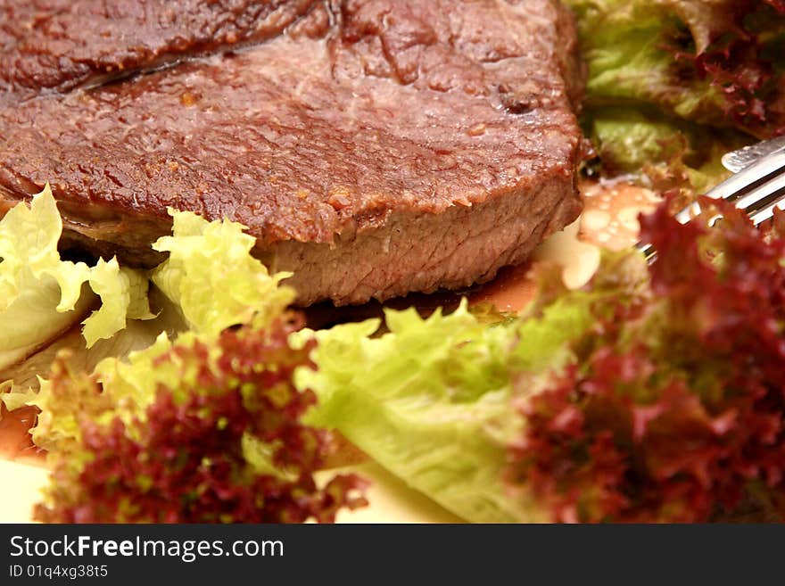 Tasty beef stеak in salad leaves. Bon appetit. Tasty beef stеak in salad leaves. Bon appetit.