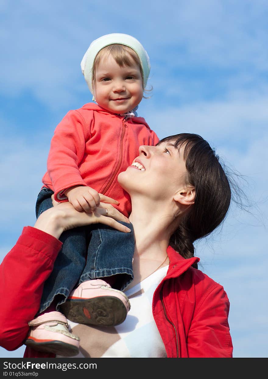 Portrait of a baby with mom outdoors on blue sky background