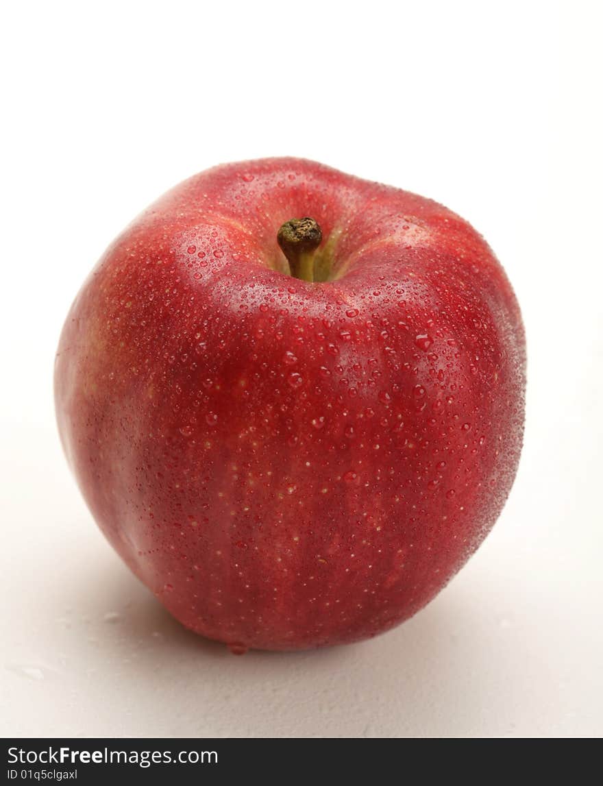 Fresh red apple with water drops on white background