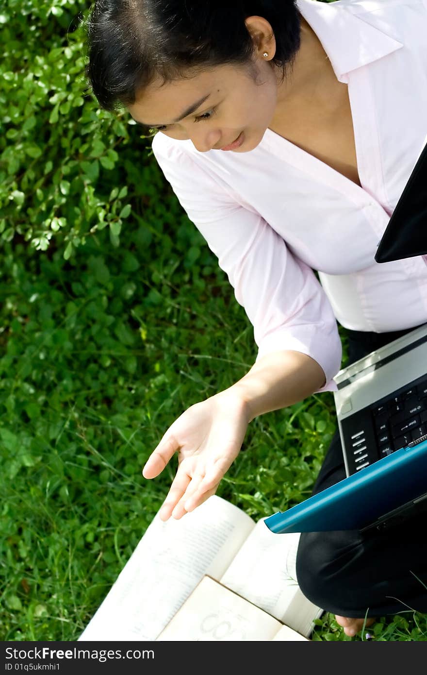 Pretty asian businesswoman seems to enjoy a discussion with her colleague during her happy working hours in green environment. Pretty asian businesswoman seems to enjoy a discussion with her colleague during her happy working hours in green environment