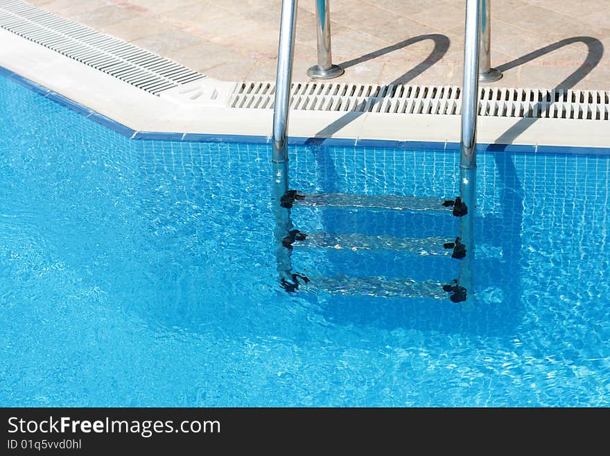 Handrail in swimming pool with blue water