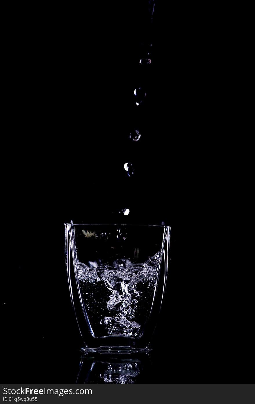 Water drops flow into glass