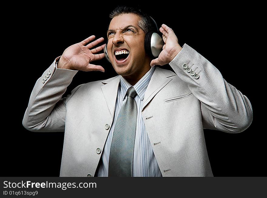 Side view of businessman listening music through headphone