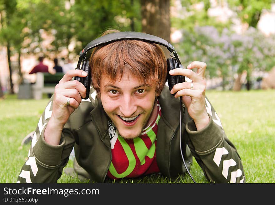 Young man young man wifh headphones sitting on the grass