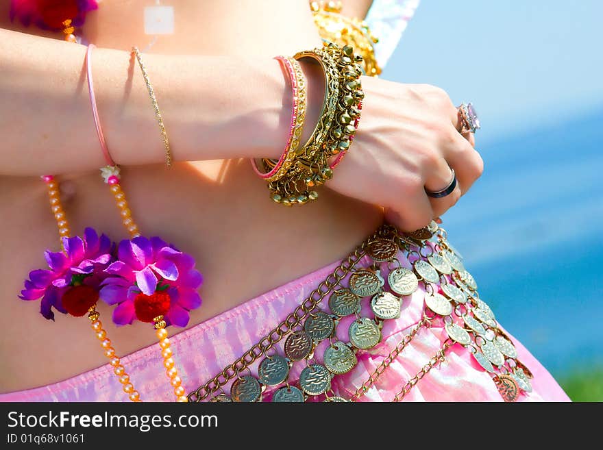 A part of a woman in asian dress close-up with rings and bracelets