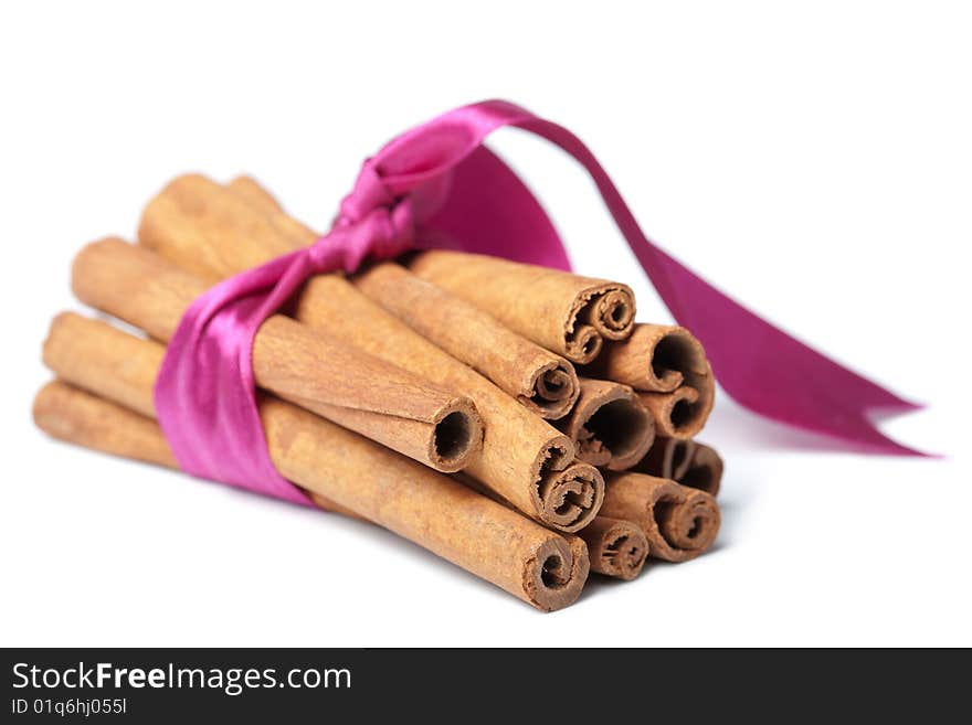 Cinnamon with pink ribbon isolated over white