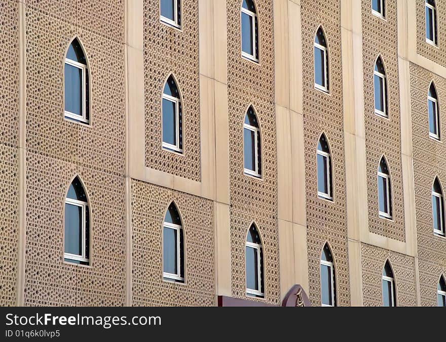 The front facia of a Dubai building showing traditional window arches.