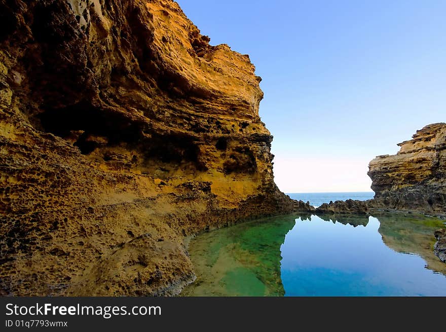 Steep cliff and calm water with reflections. Steep cliff and calm water with reflections