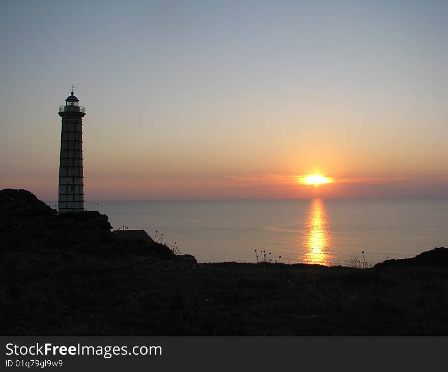 Wonderful sunset over the sea with a lighthouse