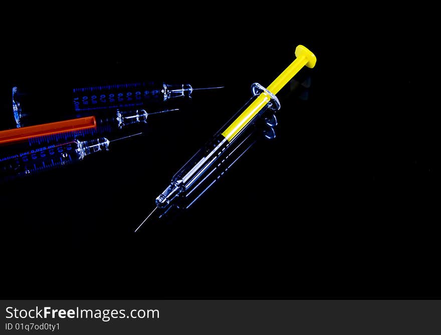 Color syringe on black background