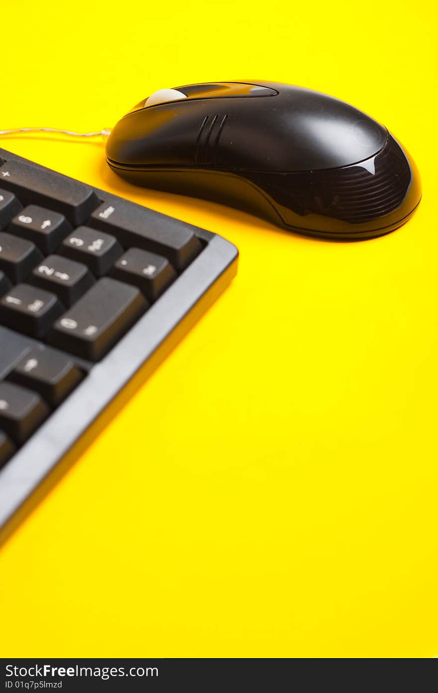 Computer mouse and keyboard isolated on yellow background