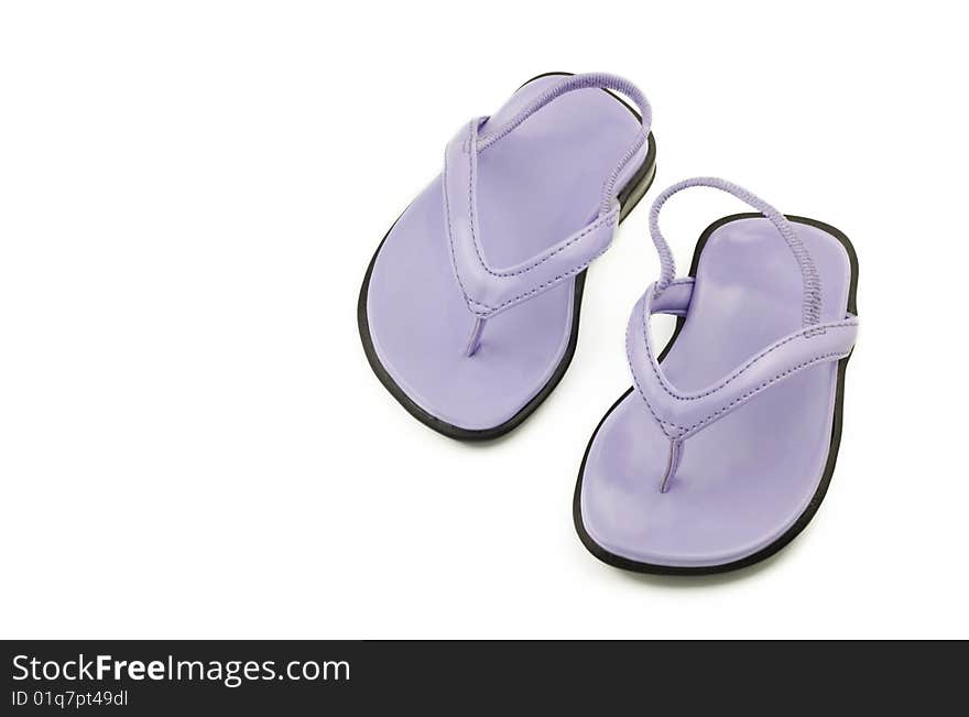 A tiny pair of newborn purple shoes or sandals for a girl, isolated on white with copy space. A tiny pair of newborn purple shoes or sandals for a girl, isolated on white with copy space